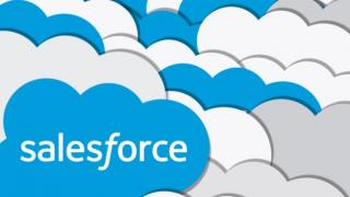 Salesforce logo, a blue cloud with white type, in front of multiple clouds overlapping in the background
